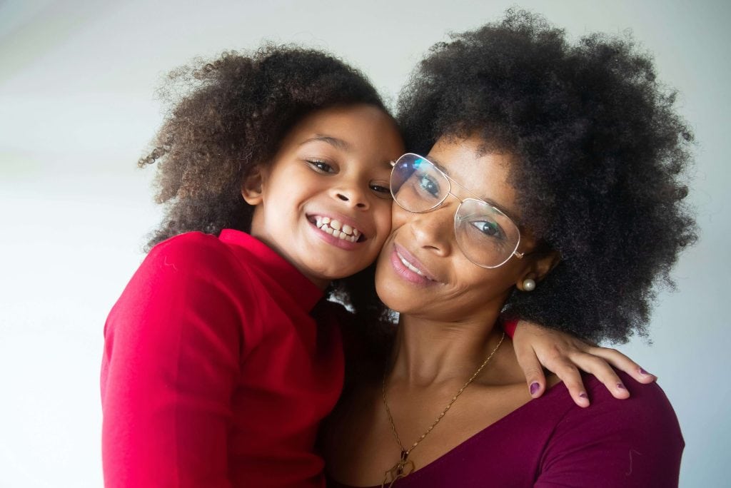 A smiling mother and daughter embrace, representing the power of parental support in helping children develop emotional resilience and positive self-talk emotion regulation skills for children