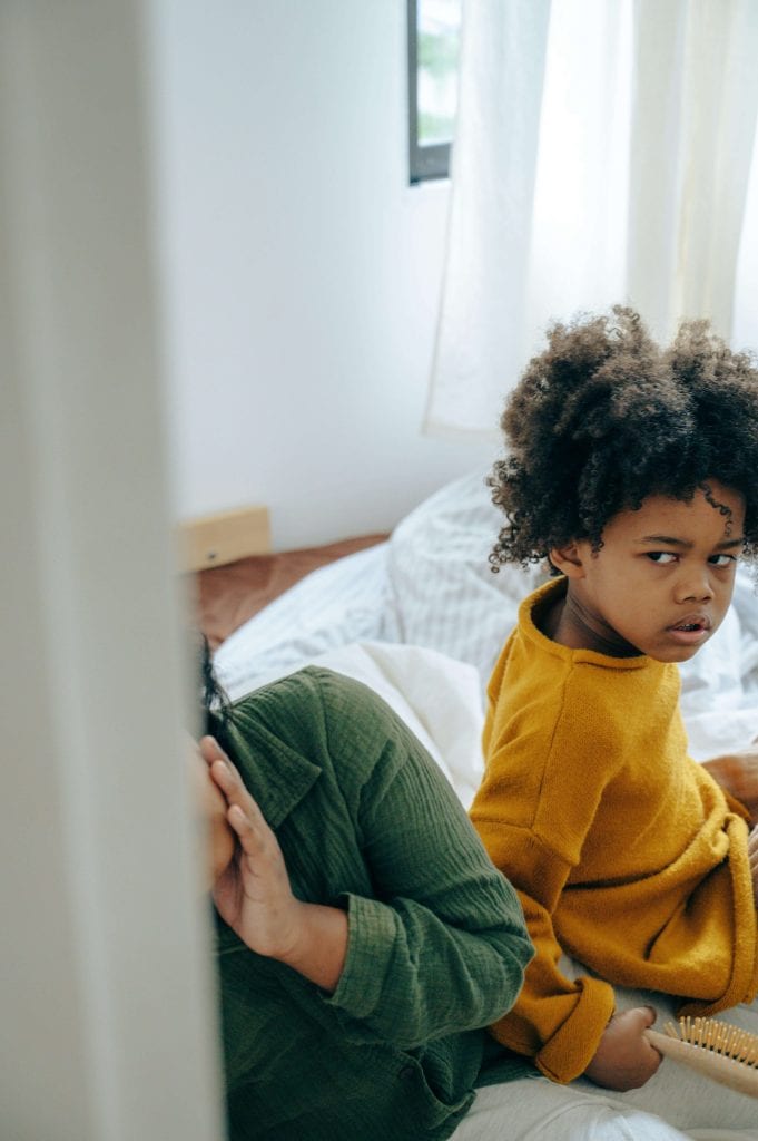 A child turns away with a distressed expression, showing signs of emotional withdrawal linked to an autistic shutdown